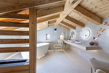 A bathroom with a bathtub and two mirrors