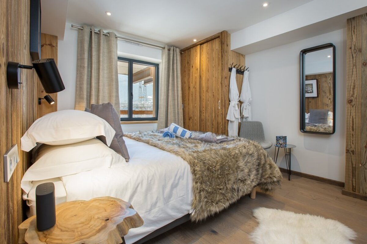 A bedroom with a large bed and a mirror