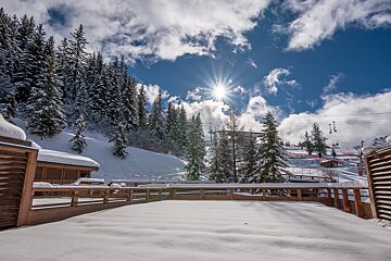 A snowy landscape with a ski lift in the background