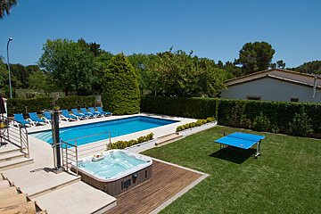 A swimming pool with a hot tub and ping pong table