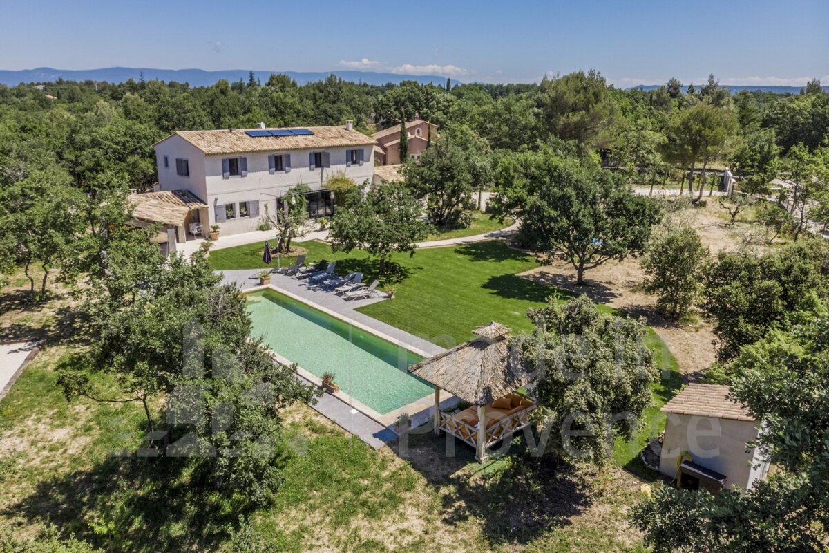 An aerial view of a large house with a large swimming pool