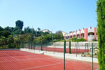 A tennis court is surrounded by a chain link fence