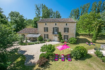 A house with a pink umbrella in front of it