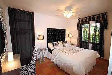 A bedroom with a bed with a white comforter that says rosso on it