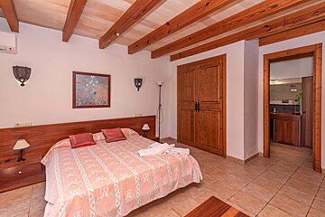 A bedroom with a bed and a picture on the wall