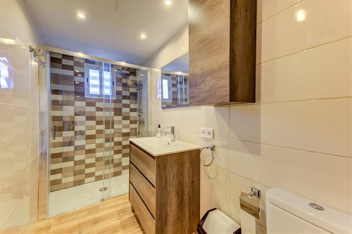 A bathroom with a walk in shower and a sink