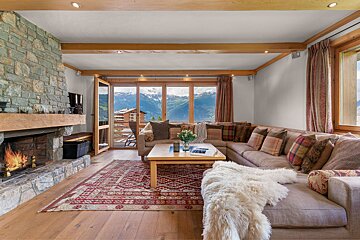 A living room with a large sectional couch and a fireplace