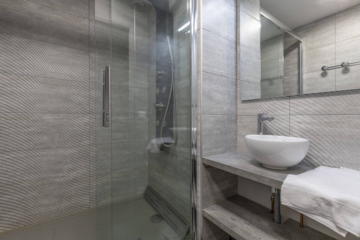 A bathroom with a sink and a walk in shower