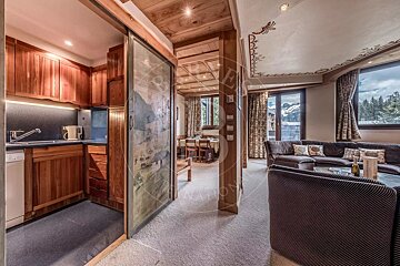 A living room with a sliding glass door leading to a kitchen