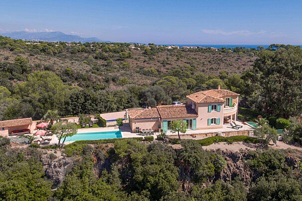 An aerial view of a house with a large swimming pool