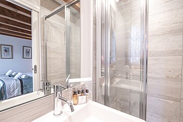A bathroom with a sink a mirror and a shower