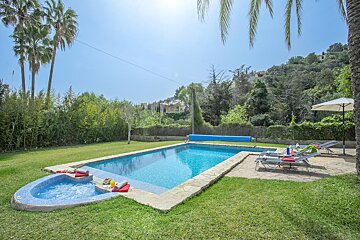 A large swimming pool surrounded by lawn chairs and umbrellas