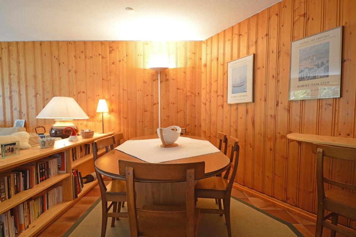 A room with a table and chairs and a poster on the wall that says robert van dine