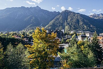 A city with mountains in the background and trees in the foreground