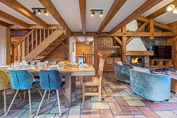 A dining room with a table and chairs and a fireplace
