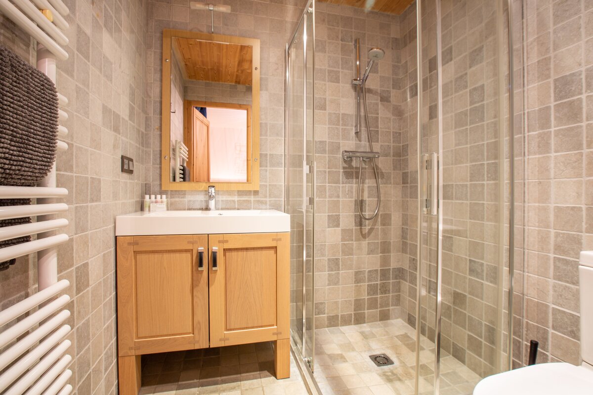 A bathroom with a walk in shower and a sink