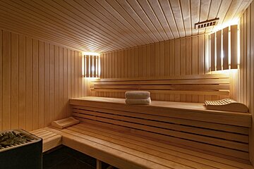 A wooden sauna with two towels on the bench