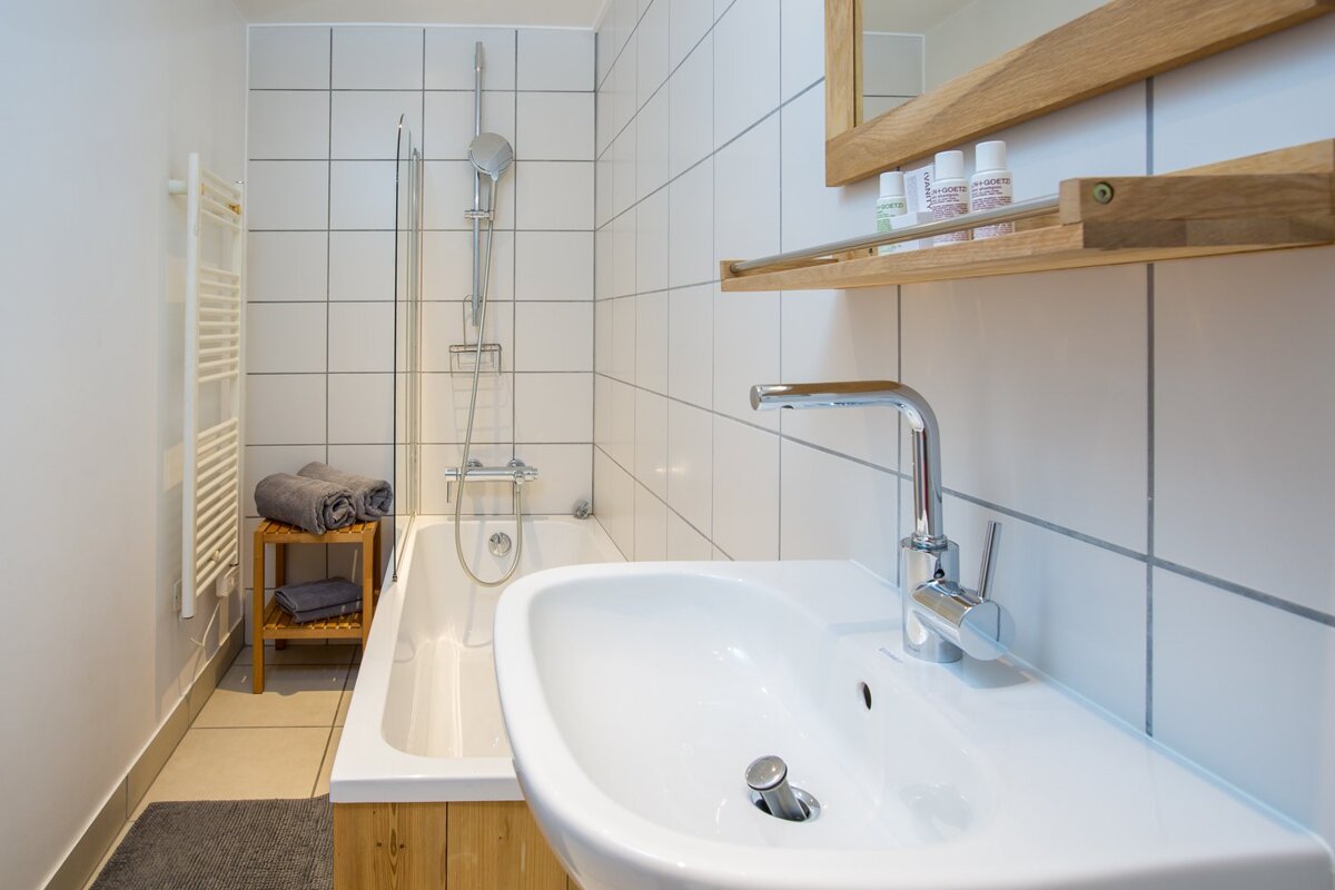 A bathroom with white tiles and a sink