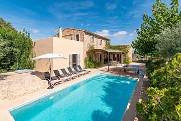 A house with a large swimming pool in front of it