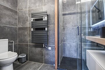 A bathroom with a toilet and a towel rack