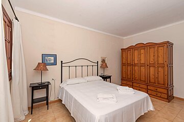 A bedroom with a large wardrobe and a bed