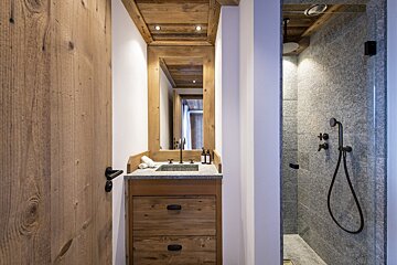 A bathroom with a sink and a walk in shower