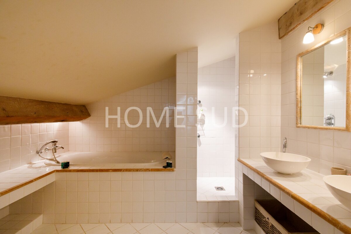 A bathroom with white tiles and the word home on the wall