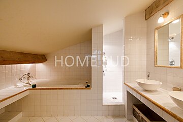 A bathroom with white tiles and the word home on the wall
