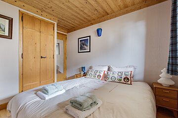 A bedroom with a bed and a picture on the wall