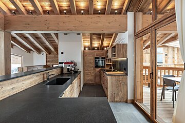 A kitchen with wooden cabinets and black counter tops