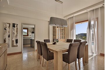 A dining room with a wooden table and chairs