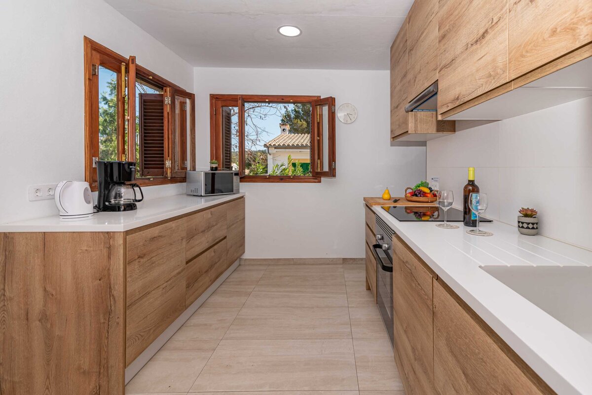 A kitchen with wooden cabinets and white counter tops