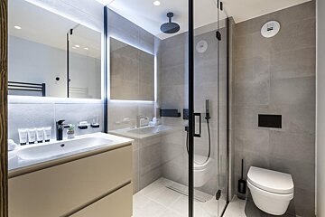 A bathroom with a toilet a sink and a mirror