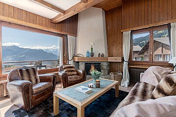 A living room with a fireplace and a view of the mountains