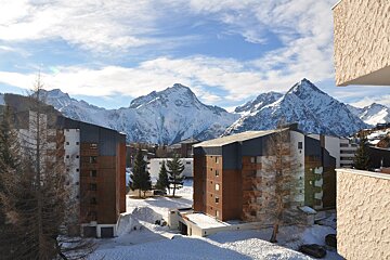 A snowy mountain behind a row of buildings