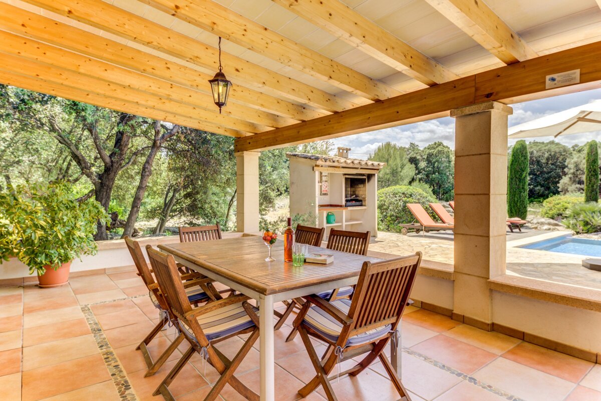 A patio with a table and chairs and a grill