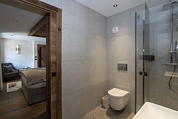 A bathroom with a toilet a sink and a shower