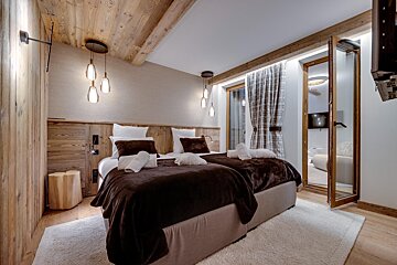 A hotel room with two beds and a television