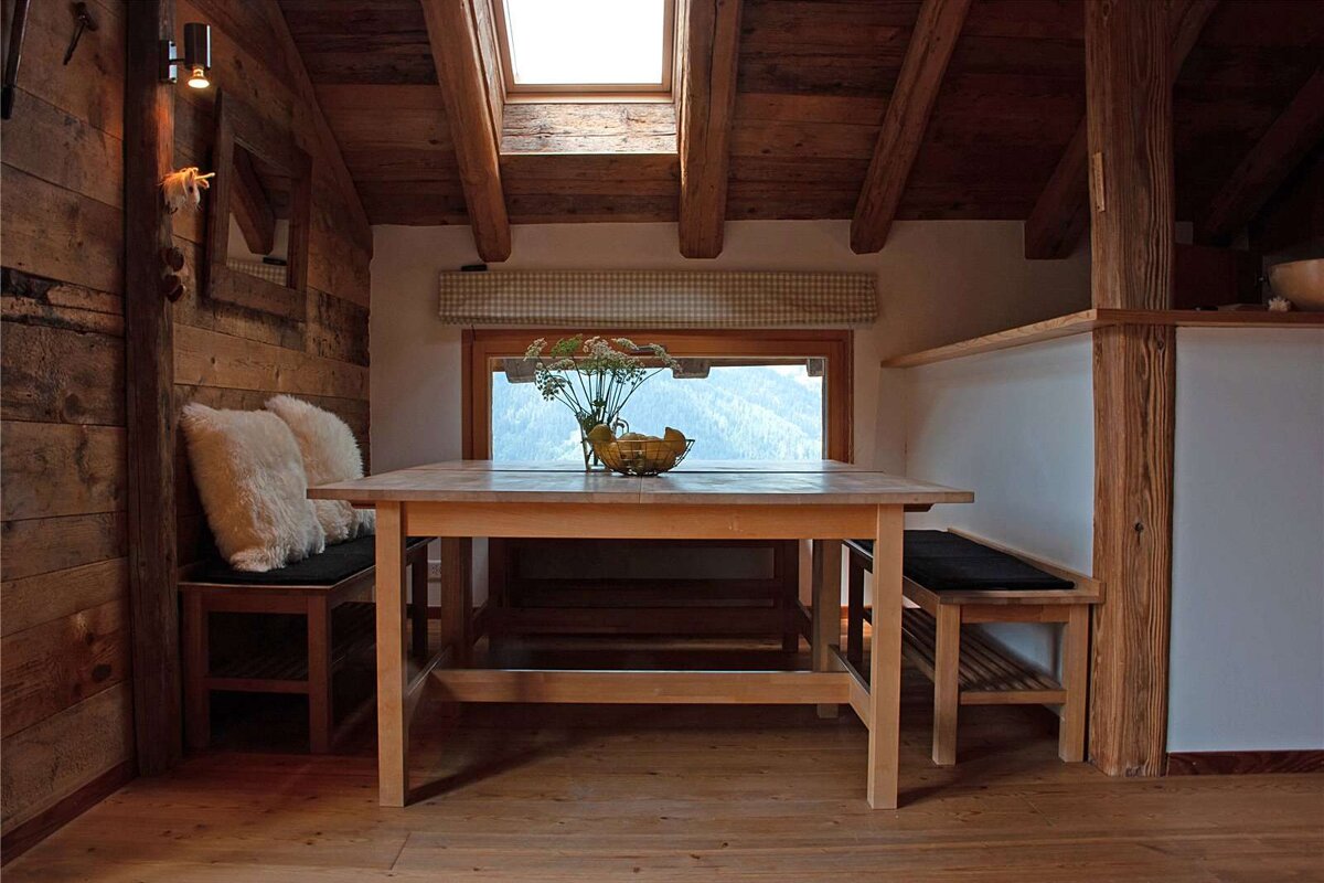 A wooden table with a vase of flowers on it