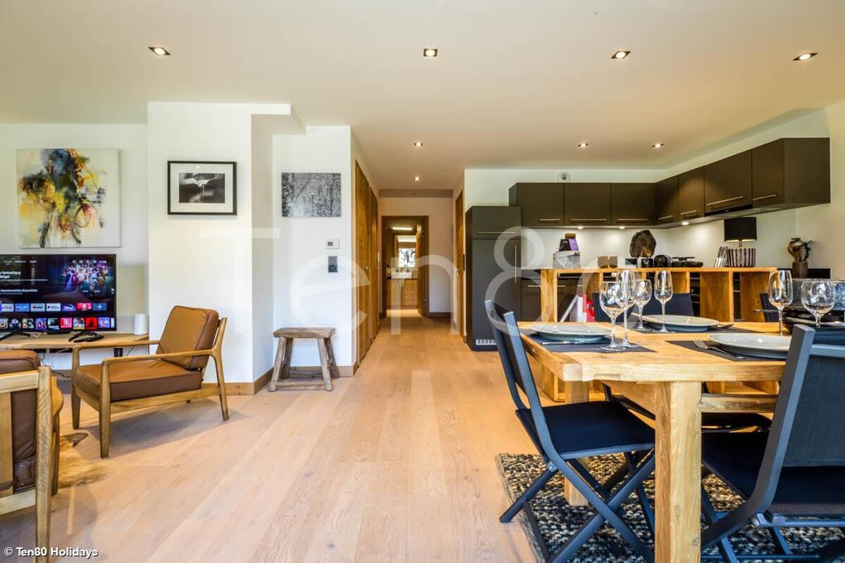 A living room with a dining table and chairs and a tv that says netflix on it