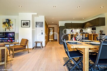 A living room with a dining table and chairs and a tv that says netflix on it