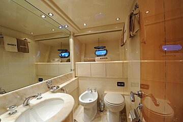 A bathroom with a toilet and a bidet with images towels on the wall