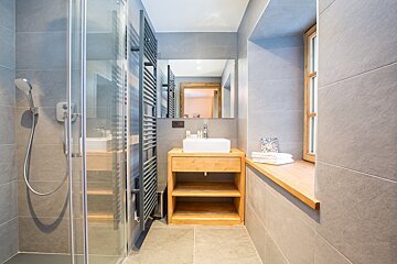 A bathroom with a sink and a walk in shower