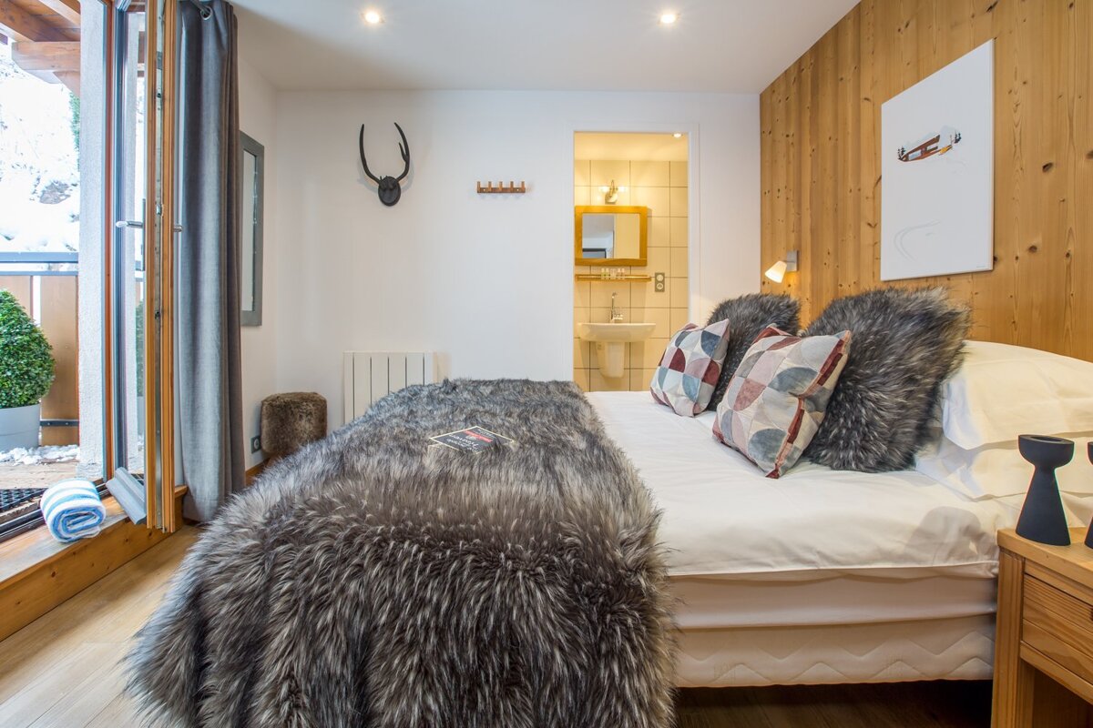 A bedroom with a fur blanket on the bed