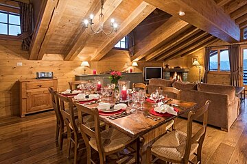 A dining room table with a vase of candles on it
