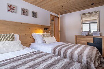 A bedroom with two twin beds and a mirror