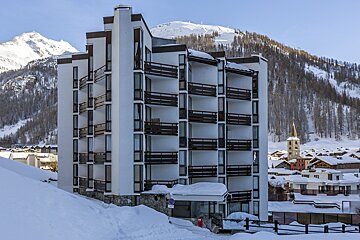A snowy building with a sign that says no parking