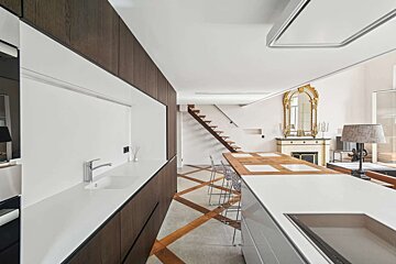 A kitchen with a large island and a staircase