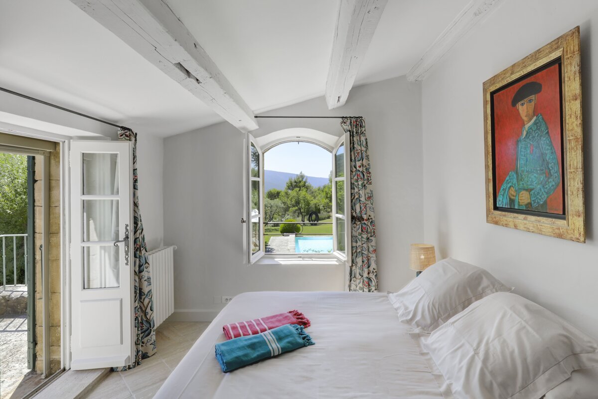 A bedroom with a painting of a man on the wall