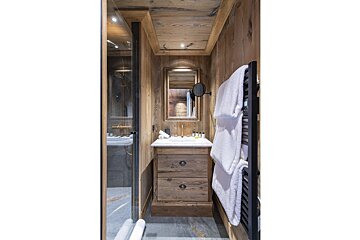 A bathroom with a sink a mirror and a towel rack